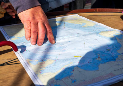 elegant-zeekaart De kapitein wijst het doel aan op de zeekaart