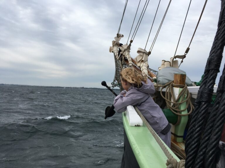 Een kind geniet van het zeilen op de Aron