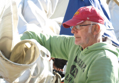 man-zeil-opdoeken Een man doekt een zeil op