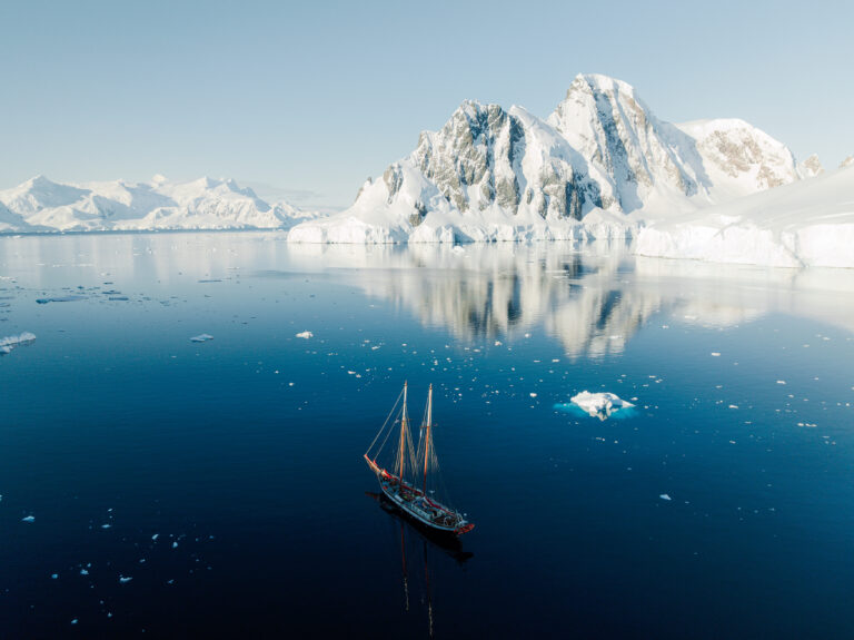 Expeditieschip tijdens zeiltour in Antarctica omringd door zee-ijs en sneeuwbergen