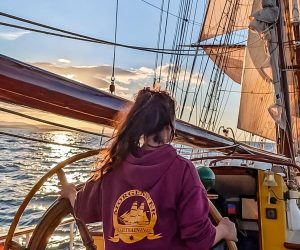 Zeilen tijdens de zonsondergang op volle zee